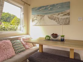 A dining room with a table and cushions at 5 Silverbow