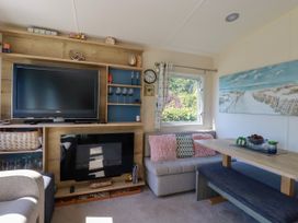 A living room with a television and sofa at Porthcurno 5 Perranwell near Goonhavern