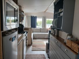 A kitchen with cabinets and a couch at Porthcurno 5 Perranwell near Goonhavern