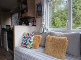 A living room with a sofa and kitchen unit at Porthcurno 5 Perranwell near Goonhavern