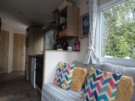 A living room with a couch and kitchen appliances at Porthcurno 5 Perranwell near Goonhavern