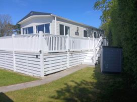 A mobile home with a deck and garden at Porthcurno 5, Perranwell near Goonhavern