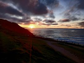 A sunset over the ocean with a path by the sea at Porthcurno 5 Perranwell near Goonhavern