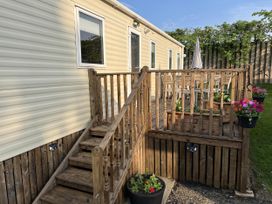 An outdoor area with a caravan and wooden deck at Hornshole Hideaway Caravan Hawick