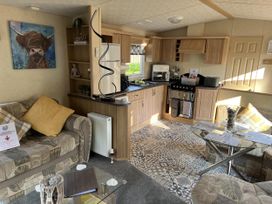 A living room with a kitchen area at Hornshole Hideaway Caravan Hawick Riverside Caravan Park near Hawick
