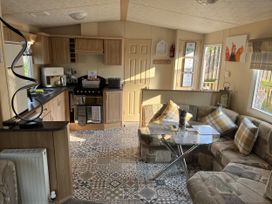 A living room with a kitchenette and seating area at Hornshole Hideaway Caravan Hawick Riverside Caravan Park near Hawick