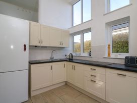 A kitchen with cabinets, sink, and refrigerator at Tegfan in Newport