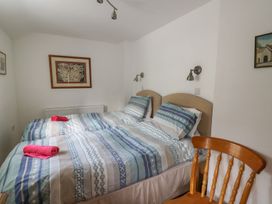A bedroom with two beds and a chair at Tegfan in Newport