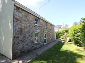 A building with a stone wall and garden furniture at Tegfan in Newport