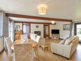 A living room with a dining table and sofa at Pillhead Cart Linhay in Bideford
