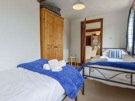 A bedroom with two beds and a wardrobe at Pillhead Cart Linhay in Bideford