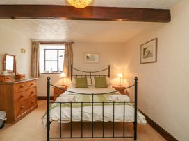 A bedroom with a bed and wooden dresser at Pillhead Cart Linhay Bideford