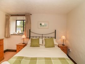 A bedroom with a bed and nightstand at Pillhead Cart Linhay Bideford