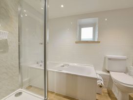 A bathroom with a bathtub, shower, toilet, and window at Pillhead Cart Linhay in Bideford