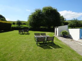 A garden with tables and chairs at Pillhead Cart Linhay in Bideford