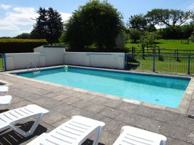 A swimming pool with loungers in an outdoor setting at Pillhead Cart Linhay in Bideford