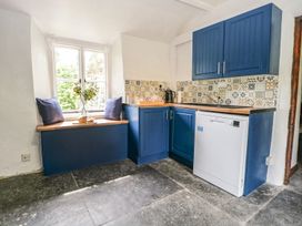A kitchen with blue cabinets and a window seat at Brigg House in Broughton-in-Furness