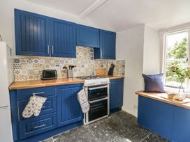 A kitchen with blue cabinets and a stove at Brigg House in Broughton-in-Furness
