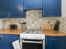 A kitchen with blue cabinets and a gas stove at Brigg House in Broughton-in-Furness