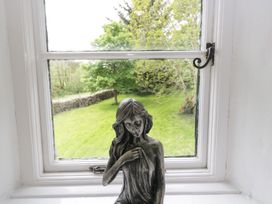 A window with a statue overlooking a garden at Brigg House in Broughton-in-Furness