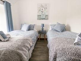 A bedroom with two beds and a nightstand at Brigg House in Broughton-in-Furness