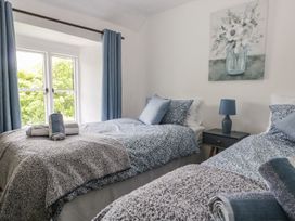 A bedroom with two beds and a nightstand at Brigg House in Broughton-in-Furness