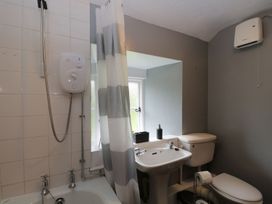 A bathroom with a bathtub, shower, sink and toilet at Brigg House in Broughton-in-Furness