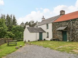 An outdoor area with a house, garden and bench at Brigg House in Broughton-in-Furness