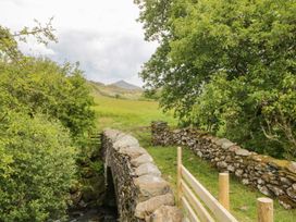 A stone bridge over water surrounded by greenery at Brigg House Broughton-in-Furness