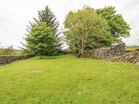 A garden with trees and stone walls at Brigg House in Broughton-in-Furness