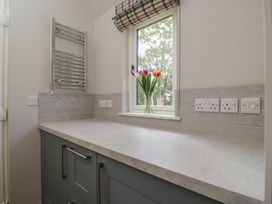 A kitchen with a window and flowers at Foxglove in Stratton Audley near Bicester