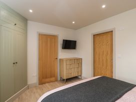 A bedroom featuring a bed, wardrobe, dresser, and television at Foxglove in Stratton Audley near Bicester