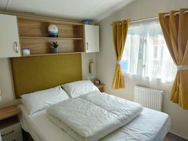 A bedroom with a bed and shelves at Clarach Bay Holiday Village W18 Aberystwyth