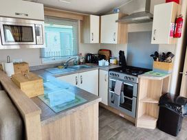 A kitchen with appliances and cabinets at Clarach Bay Holiday Village W18 Aberystwyth