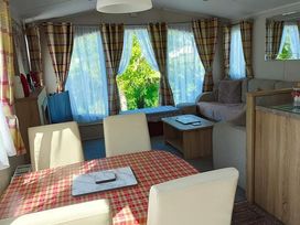 A living room with a dining table and sofa at Clarach Bay Holiday Village W18 Aberystwyth