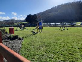 A playground with slides and swings at Clarach Bay Holiday Village W18 in Aberystwyth