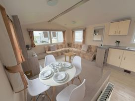 A living room with a sofa and dining area at Holiday Park Seawick in Clacton-on-Sea