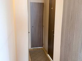 A hallway with doors and a floor mat at Holiday Park Seawick Clacton-on-Sea