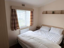 A bedroom with a bed and window at Holiday Park Seawick, Clacton-on-Sea