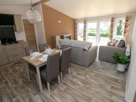 A living room with a dining table and chairs at Sandpiper in Narberth
