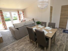 A living room with a sofa and dining table at Sandpiper in Narberth