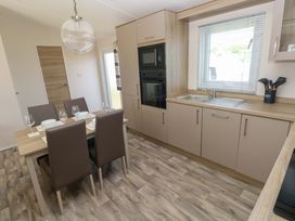 A kitchen with a dining table and chairs at Sandpiper in Narberth