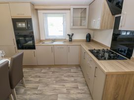 A kitchen with a sink and gas stove at Sandpiper in Narberth