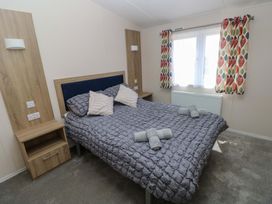 A bedroom with a double bed and nightstand at Sandpiper in Narberth