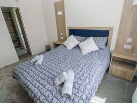 A bedroom featuring a bed and bedside table at Sandpiper in Narberth
