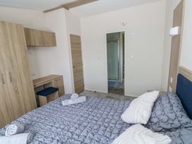 A bedroom with a bed and wardrobe at Sandpiper in Narberth