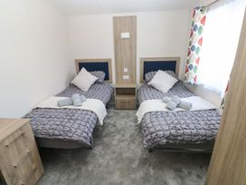 A bedroom with twin beds and a dresser at Sandpiper in Narberth