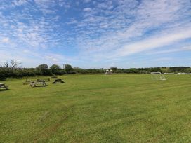 An outdoor area with picnic tables and soccer goals at Sandpiper in Narberth
