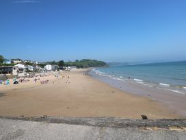 A beach with people and tents near houses at Sandpiper in Narberth