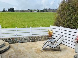 An outdoor area with loungers and a view of the lawn at O7 in Abersoch